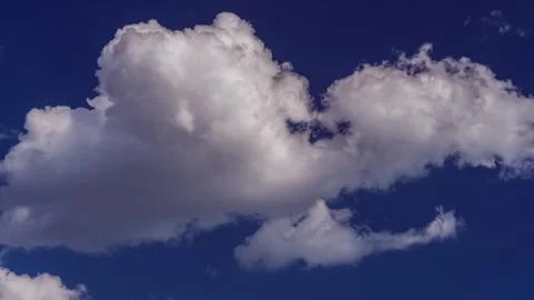White clouds float across the blue sky Stock Photos