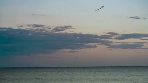 White clouds float across the blue sky above the sea Stock Photos