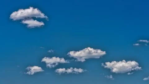 White clouds float across the blue sky Stock Photos