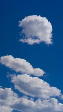 White clouds float across the blue sky Stock Photos
