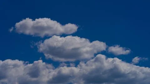 White clouds float across the blue sky Stock Photos