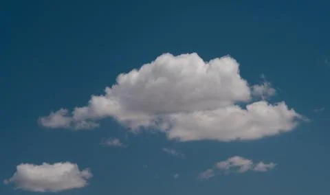 White clouds float across the blue sky Stock Photos