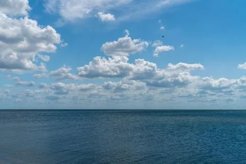 White clouds float across the blue sky above the sea-HDR Stock Photos