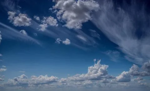 White clouds float across the blue sky Stock Photos