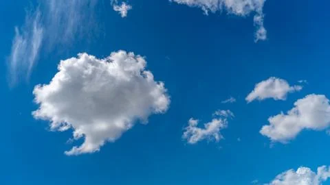 White clouds float across the blue sky Stock Photos