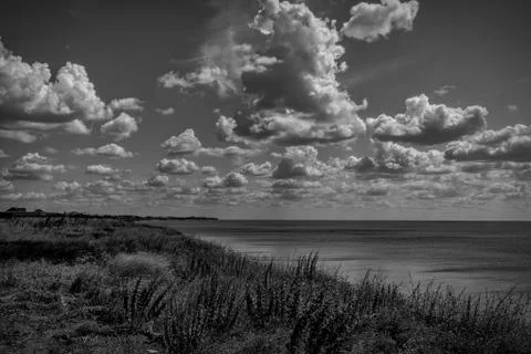 White clouds float across the blue sky over the cliff Stock Photos