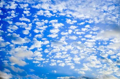 White clouds float across the blue sky Stock Photos