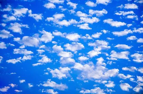 White clouds float across the blue sky Stock Photos