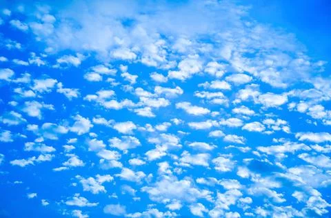 White clouds float across the blue sky Stock Photos