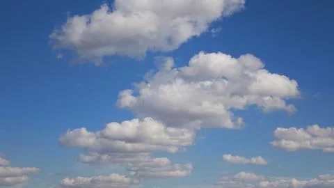 White clouds float across the blue sky. Puffy fluffy soft clouds Stock Photos