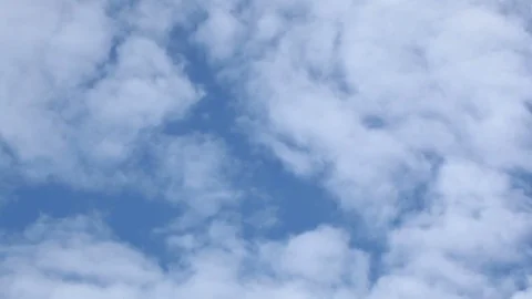 White clouds float against the background of the light blue sky Stock Footage 77453460