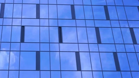 White clouds float in sky reflecting in building windows Video stock 134998805