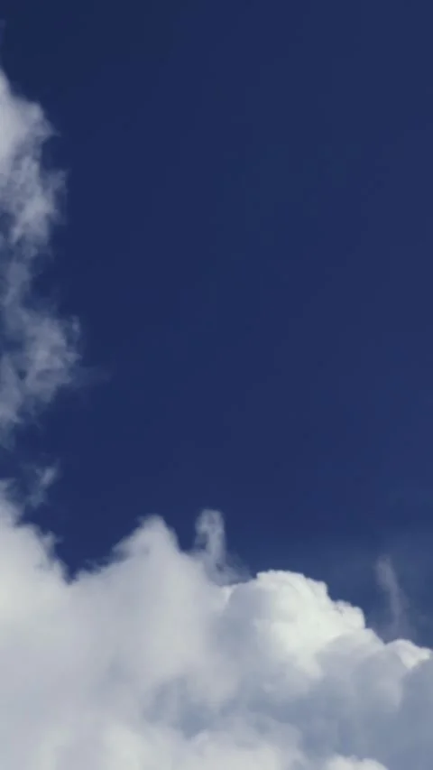 White clouds float slowly across deep blue summer sky. Video stock 340332384