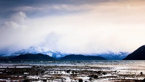 White clouds floating over snow covered mountains and Wanaka lake Stock Footage 76103473