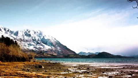 White clouds floating over snow covered mountains and Wanaka lake Stock Footage 76103491