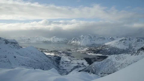 White clouds floating over snow covered mountain ranges and frozen rivers Stock Footage 113227494
