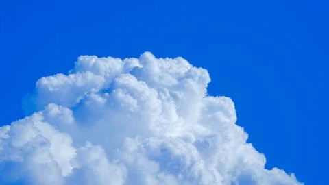 White clouds floating in the sky are caused by steam forming on a bright day. Stock Photos