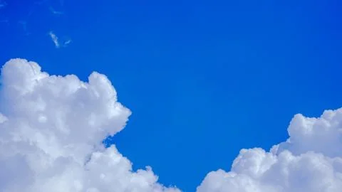 White clouds floating in the sky are caused by steam forming on a bright day. Stock Photos