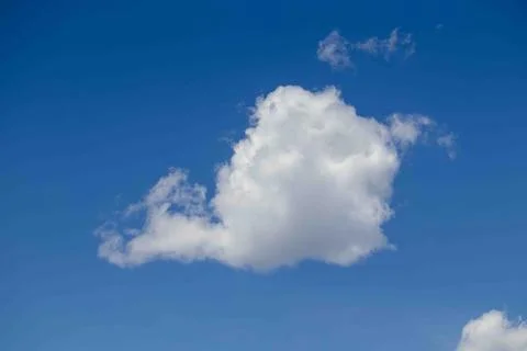 White clouds fly over with blue skies behind Stock Photos