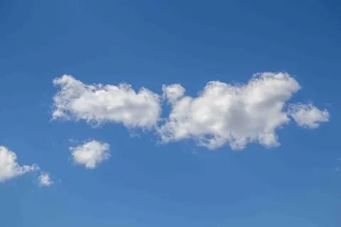 White clouds fly over with blue skies behind Stock Photos