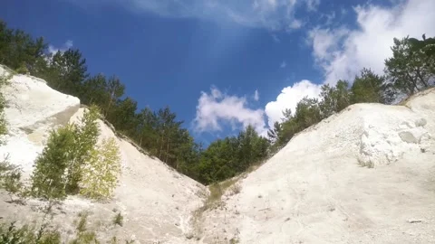 White clouds fly over the chalky slopes overgrown with spruce Stock Footage 133251110
