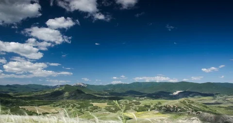 White clouds fly over the green valley and mountains Stock Footage 90505502