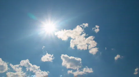 White clouds flying on blue sky with sun rays Stock Footage
