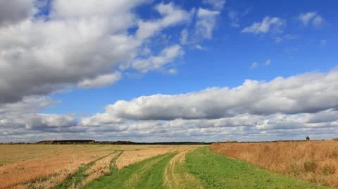 White clouds flying on blue sky over autumn yellow field Stock Footage 12249176