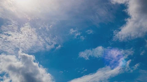White clouds flying on blue sky with sun rays. Sun beams. Time lapse. Video stock 82537051
