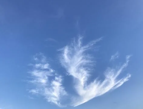 White clouds formed like flames in a fireplace in the clear blue sky Stock Photos