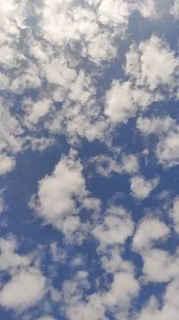 White clouds forming on deep blue sky on sunny day Stock Photos