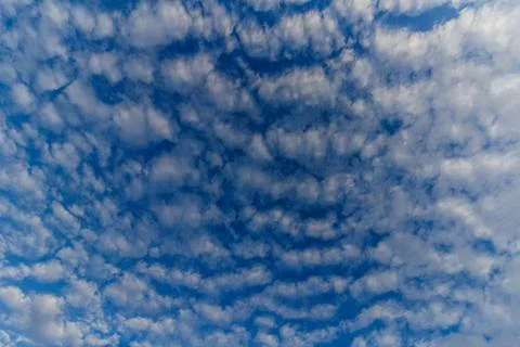White clouds in front of a blue sky Stock Photos