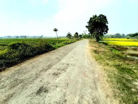 White clouds in the green fields and blue sky around the paved streets of the Stock Photos