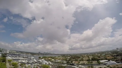 White clouds grow against blue sky over city waterway, boats 库存影片 67092053