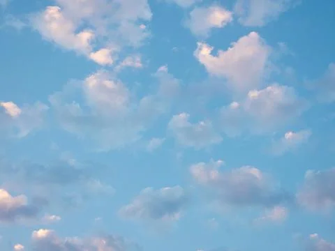 White clouds in the light of the rising sun on the blue sky Stock-Fotos