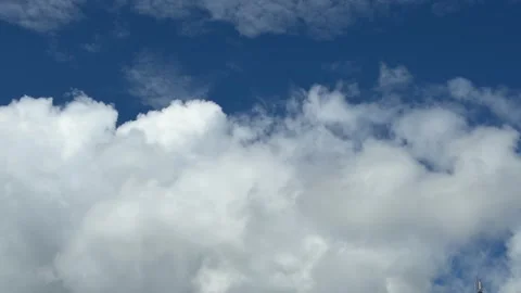 White clouds move across a blue sky above an open natural landscape. Cloudscape. Stock Footage 339279870