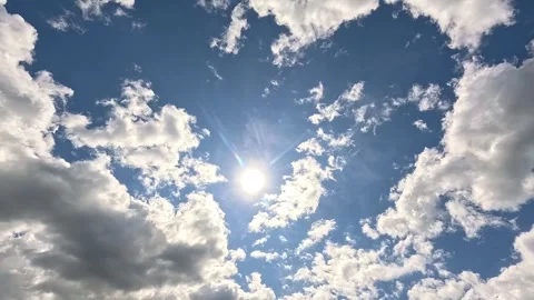White clouds move across the blue sky with the bright sun. timelapse Stock Footage 340331082