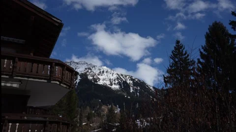 White clouds moving above snow capped alpine mountains timelapse Stock Footage 328428508