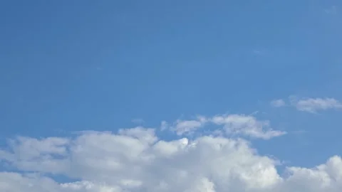 White clouds moving across blue sky background Stock Footage 345484259