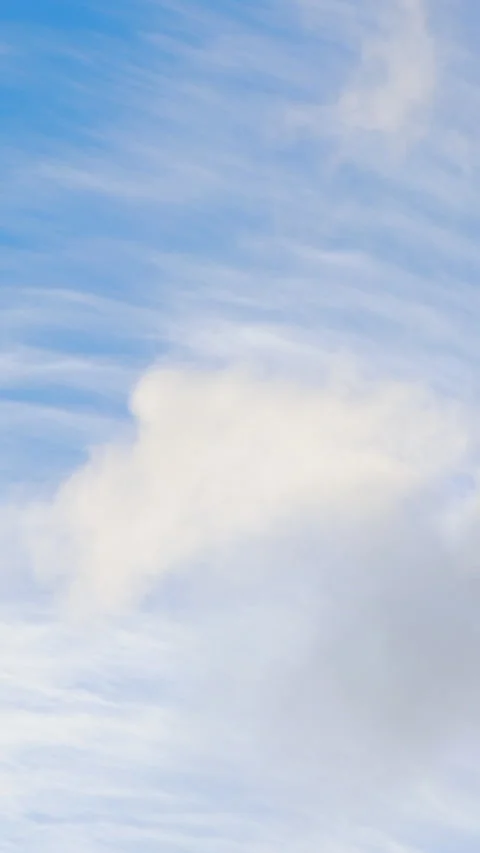 White clouds moving across bright blue sky. Vertical Stock Footage 334658404