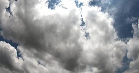White Clouds Moving Across a Clear Blue Sky Stock Photos