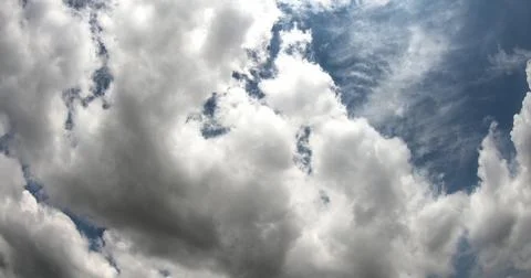 White Clouds Moving Across a Clear Blue Sky Stock Photos