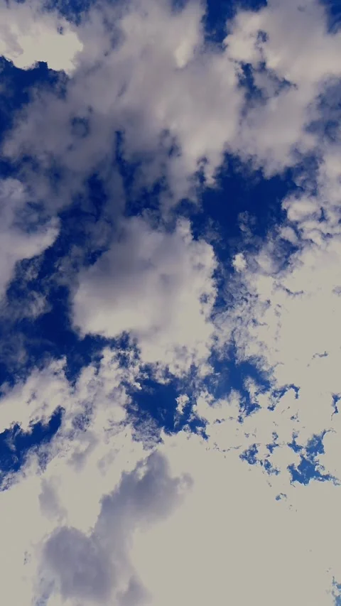 White clouds moving across a deep blue sky timelapse. 4K Vertical Stock Footage 330788288