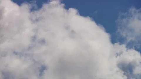 White clouds moving and dissipating against a blue sky Stock Footage 329757370