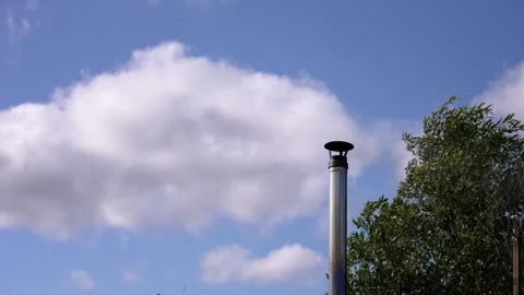 White clouds moving in blue sky behind chimney Stock Footage 344861186