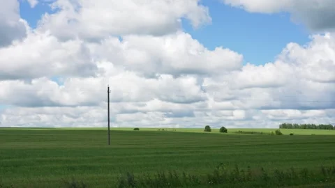White clouds moving over a green agricultural field Stock Footage 338383514