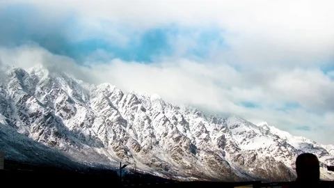 White clouds moving over snow covered mountains Stock Footage 76104833