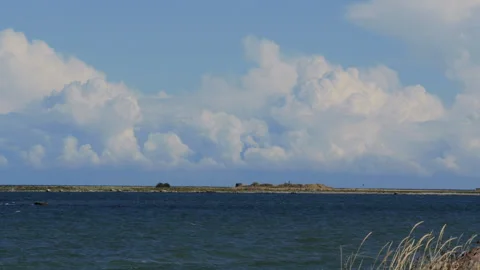 White clouds moving over the wavy blue sea Stock Footage 343857553