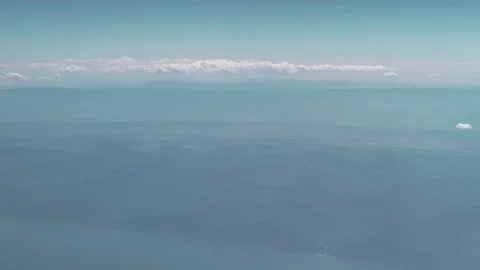 White clouds over the mountain range along the seashore. View from an airplane Stock Footage 255214232