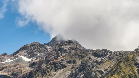 White clouds over rocky alps mountain peak in New Zealand wilderness landscape Stock-Footage 117292980